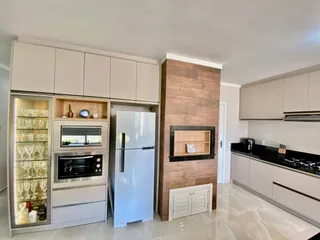 Cozinha moderna com armários brancos e eletrodomésticos em um ambiente claro.