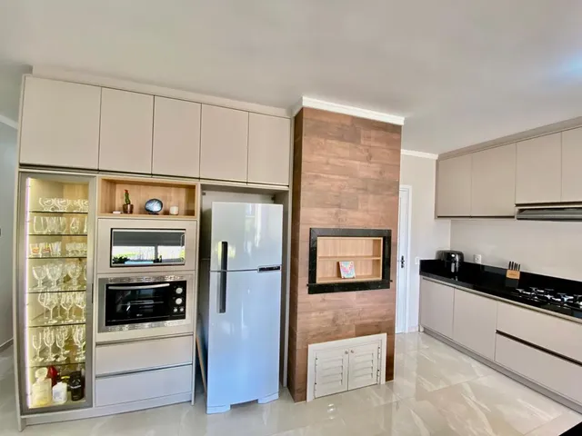 Cozinha moderna com armários brancos e eletrodomésticos em um ambiente claro.