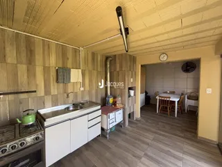 Foto de uma cozinha com revestimento de madeira e bancada branca.