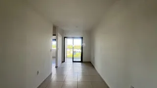 Corredor interno de uma residência com piso de cerâmica clara.