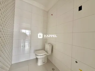 Foto de um banheiro com revestimento branco e piso de cerâmica.