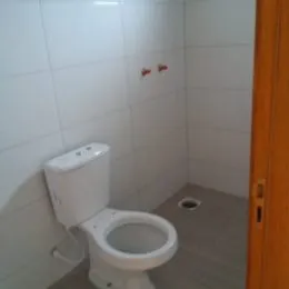 Foto de um vaso sanitário branco em um ambiente com azulejos brancos.