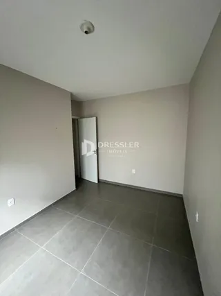 Foto de um ambiente interno com piso de cerâmica e paredes claras.