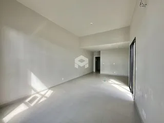 Vista interna de um corredor amplo com paredes brancas.