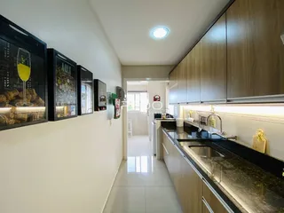 Vista interna de uma cozinha com armários e bancadas em um imóvel no Brasil.