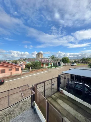Vista externa da propriedade com muro e cerca de tijolos.