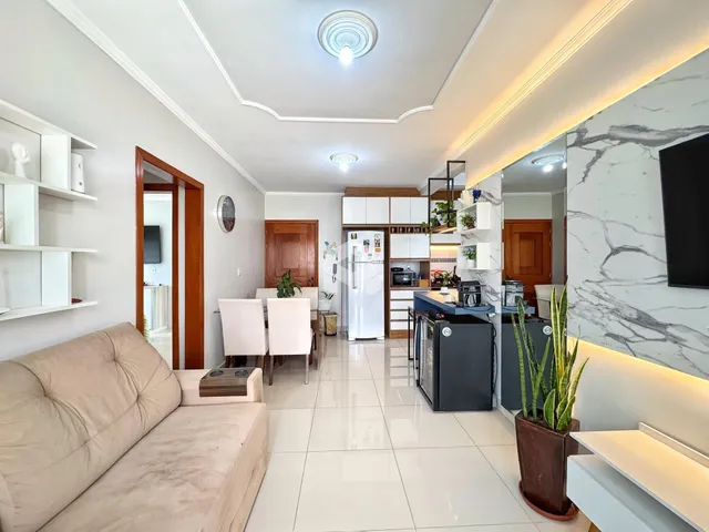 Sala de estar e cozinha moderna com piso de cerâmica clara.