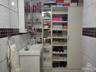 Foto de uma cozinha com armários brancos e prateleiras abertas.