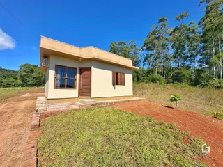 Fachada de uma casa em Lajeado, Brasil, com vegetação ao fundo.