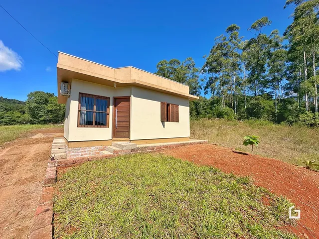 Fachada de uma casa em Lajeado, Brasil, com vegetação ao fundo.
