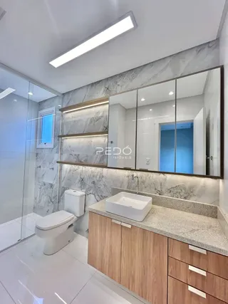 Foto de um banheiro moderno com revestimento branco e bancada clara.