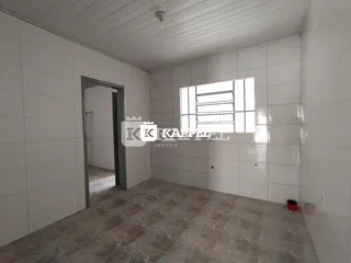 Foto interna de um cômodo com paredes brancas e piso de cerâmica.
