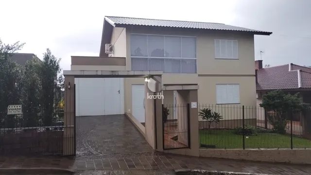 Fachada de uma residência com garagem e cerca em Lajeado, Brasil.