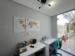 Ambiente interno com parede decorada por mapas e acesso a uma área externa.