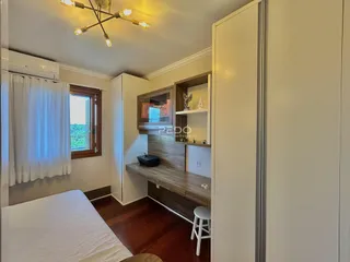 Quarto com piso de madeira e armário embutido.