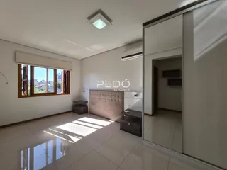 Sala de estar com piso de cerâmica e grande janela de madeira.