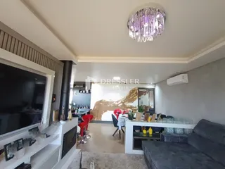 Sala de estar moderna com lareira e televisão em um imóvel no Brasil.
