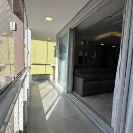 Hall de entrada com piso claro e portas de vidro.