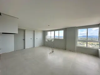 Ambiente interno amplo com paredes brancas e piso de concreto.