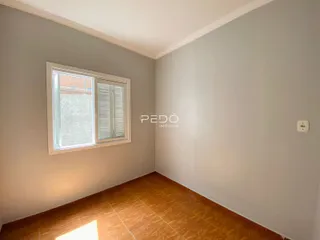 Quarto interno com piso de cerâmica e parede cinza claro.