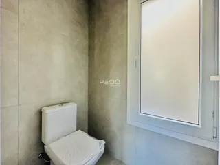 Foto de um banheiro interno com paredes texturizadas e vaso sanitário branco.