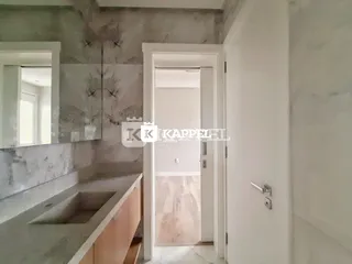 Foto de um banheiro com bancada de mármore e porta de entrada para outro cômodo.