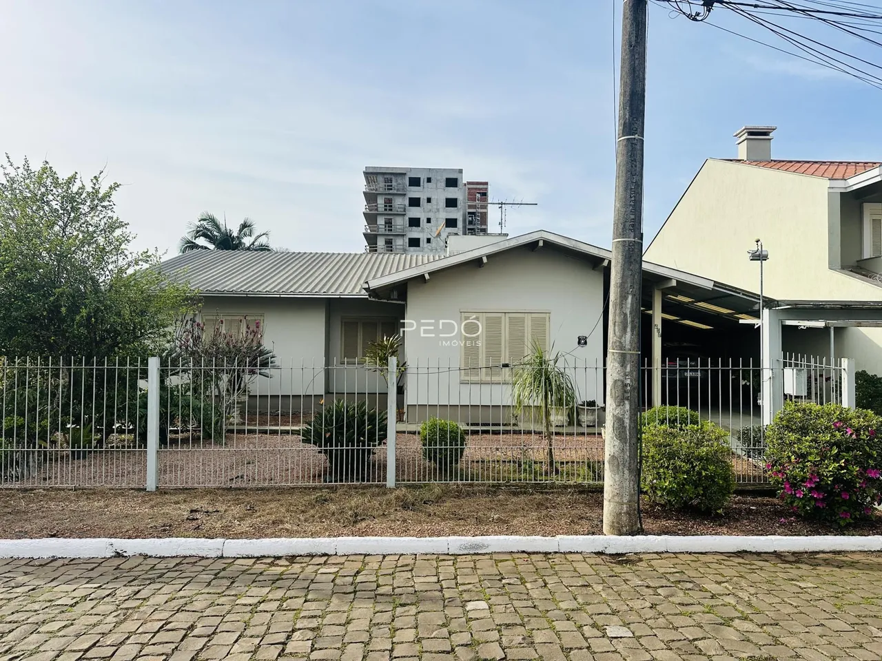 Fachada de uma casa em Lajeado, Brasil, com cerca e jardim.