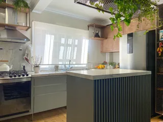 Cozinha moderna com bancada de granito e armários em tons neutros.