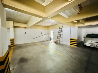 Espaço interno de um imóvel com piso de concreto e estrutura exposta.