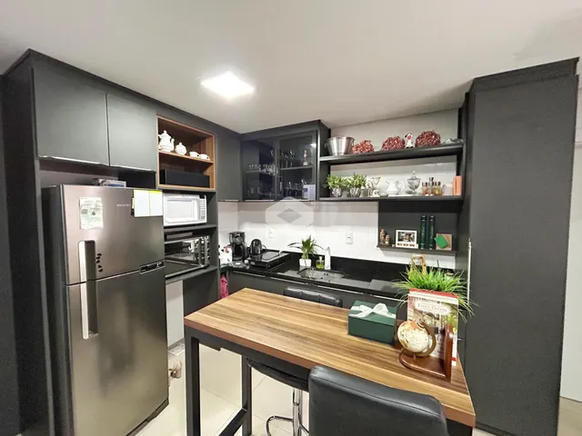 Foto de uma cozinha moderna com armários escuros e eletrodomésticos de aço inoxidável.