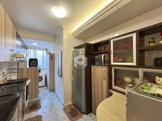 Ambiente de sala e cozinha com armários e decoração em imóvel.