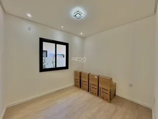 Ambiente interno de uma sala com paredes brancas e piso claro.