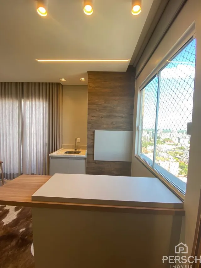 Vista de uma área de cozinha com balcão e grande janela.