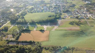 Vista aérea de uma propriedade rural com campos e áreas arborizadas.