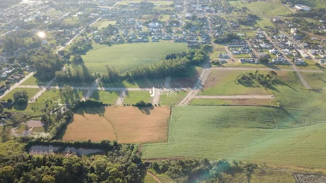 Vista aérea de uma propriedade rural com campos e áreas arborizadas.