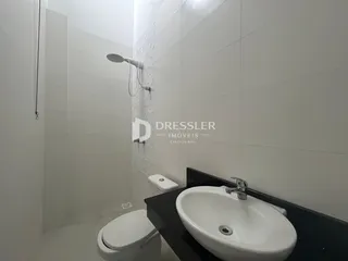 Banheiro com paredes brancas e revestimento de azulejo.