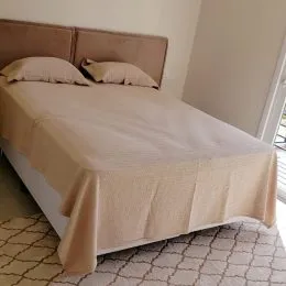 Foto de um quarto com cama de casal e roupa de cama.