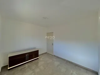 Ambiente interno de uma sala com piso de cerâmica e móvel de madeira.