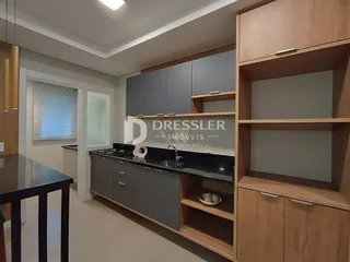 Imagem de uma cozinha moderna com armários cinzas e madeira clara.