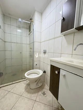 Foto de um banheiro com box de vidro e vaso sanitário.