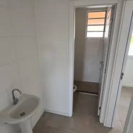 Foto de um banheiro interno com revestimento de azulejos brancos.