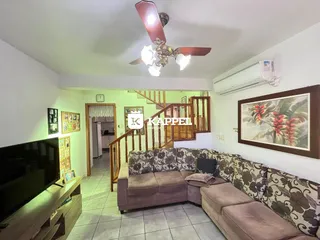 Sala de estar com sofá e televisão em um apartamento.