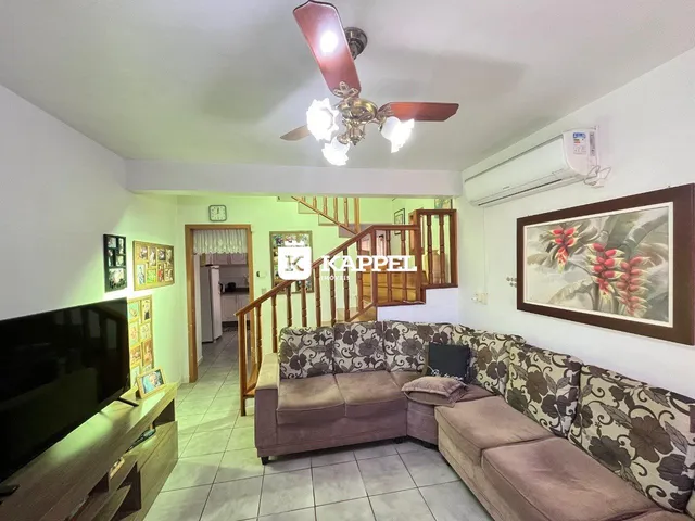 Sala de estar com sofá e televisão em um apartamento.