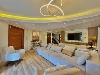Sala de estar moderna com sofá e piso de madeira clara.