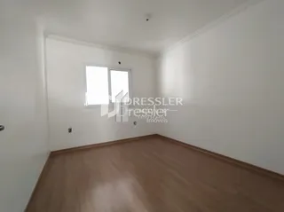 Ambiente interno de uma sala com piso de madeira clara.