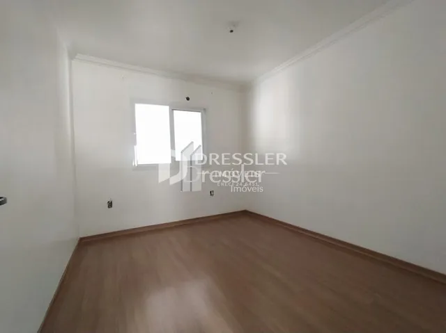 Ambiente interno de uma sala com piso de madeira clara.