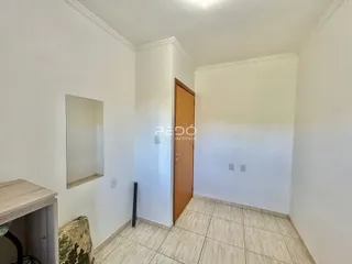 Hall de entrada com piso de cerâmica e porta de madeira clara.