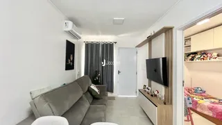Sala de estar com sofá cinza e cortinas.