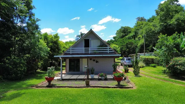 Fachada de uma casa residencial com jardim verde e paisagismo.