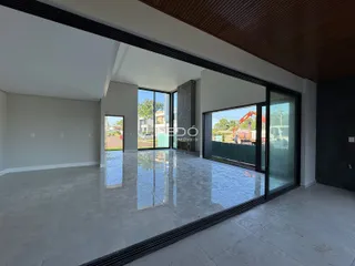 Ambiente interno de uma sala com piso de cerâmica e grandes portas de vidro.